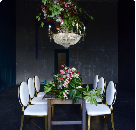 rich-christal-chandelier-hangs-dinner-table-with-red-roses-greenery